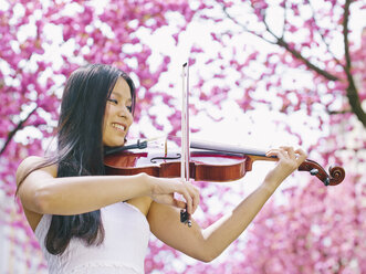 Female viola player in front of blossoming cherry tree - MADF000191