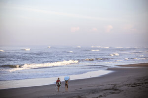 Indonesien, Bali, zwei Frauen mit Surfbrettern am Strand - KNTF000004