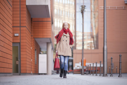 Junge Frau mit rotem Halstuch und roter Ledertasche - MMFF000833