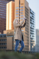 Deutschland, Berlin, junge Frau nimmt ein Selfie mit Phablet - MMFF000838