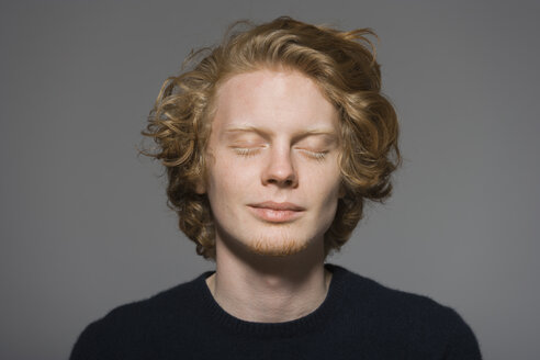 Portrait of young man with closed eyes - TCF004613