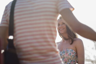 Smiling young woman looking at man outdoors - UUF003878