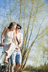 Playful young couple with bicycle - UUF003880