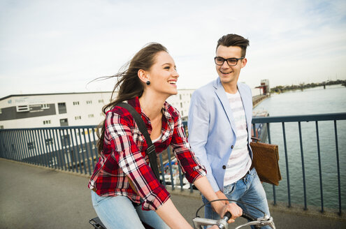 Germany, Mannheim, young man and woman with bicycle on bridge - UUF003912