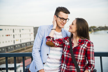 Germany, Mannheim, smiling young couple on bridge - UUF003923