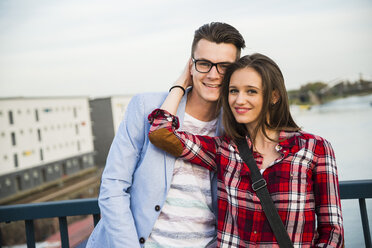 Germany, Mannheim, smiling young couple on bridge - UUF003924