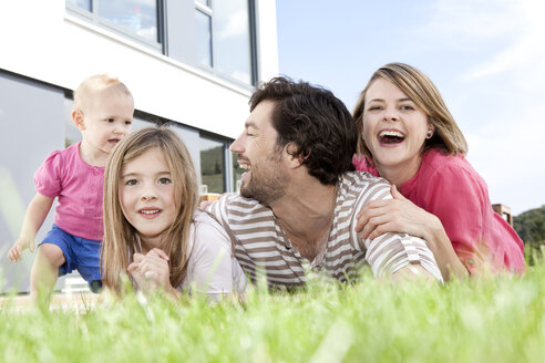 Glückliche Familie auf dem Rasen liegend - MFRF000171