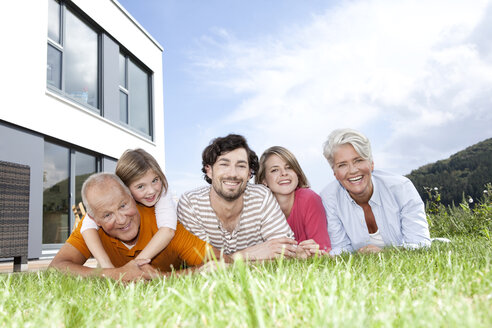 Portrait of happy extended family lying on lawn - MFRF000173