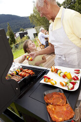 Grandfather and granddaughter at barbecue grill - MFRF000201