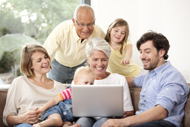 Großfamilie auf der Couch mit Laptop - MFRF000228