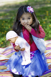 Kleines Mädchen spielt im Freien mit einer Puppe - GDF000710