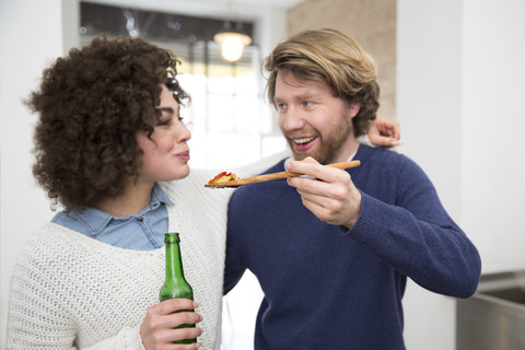 Ehepaar kocht in der Küche und probiert Essen, lizenzfreies Stockfoto