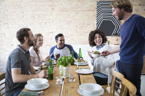 Glückliche Freunde beim gemeinsamen Essen - FKF000995