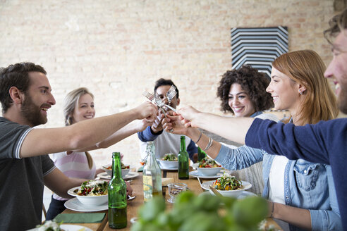 Glückliche Freunde beim gemeinsamen Essen - FKF000997