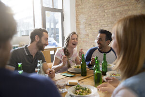 Glückliche Freunde beim gemeinsamen Essen - FKF000959