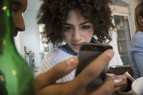 Junger Mann zeigt einem Freund sein Smartphone, lizenzfreies Stockfoto