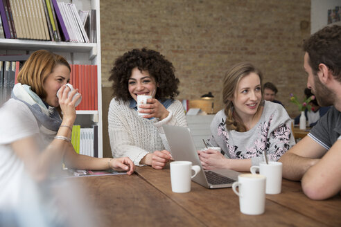 Gruppe von Freunden mit Laptop in einer Cafeteria - FKF001025