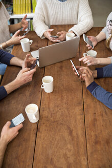 Eine Gruppe von Freunden benutzt Smartphones in einer Cafeteria - FKF000986