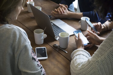 Gruppe von Freunden mit Laptop und Smartphones in einer Cafeteria - FKF001018