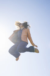 Junge Frau springt bei Gegenlicht in die Luft - ABZF000022