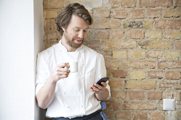 Cook with espresso cup and smartphone having a rest - FKF001045