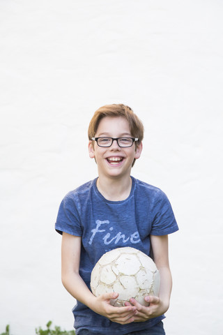 Porträt eines lachenden Jungen mit Fußball, lizenzfreies Stockfoto