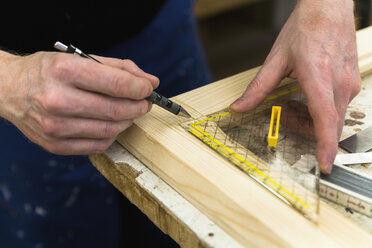 Rahmenbauer in der Werkstatt beim Anzeichnen eines Holzrahmens - TCF004647