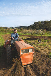 Farmer with tractor on field with dog watching - GEMF000232