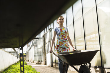 Junge Gärtnerin bei der Arbeit in einer Gärtnerei - UUF003997