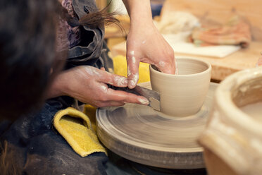 Potter in workshop working on potters wheel - MAEF010372