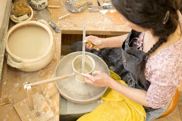 Potter in workshop working on potters wheel - MAEF010375