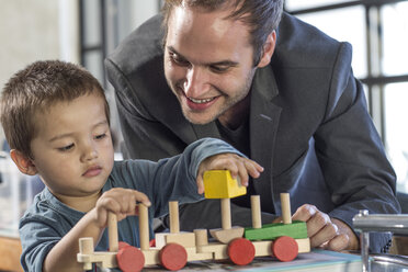 Vater und Sohn spielen mit Spielzeugeisenbahn - ZEF004434