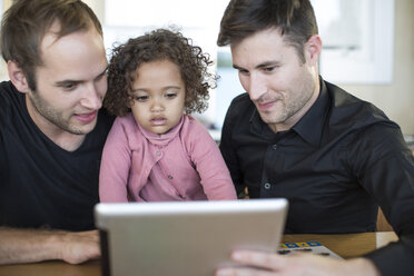 Two men with kid looking at digital tablet - ZEF004441