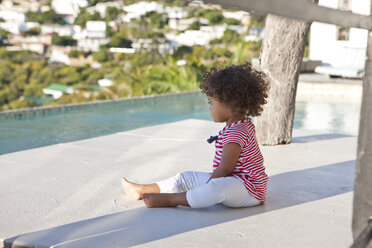 Little girl with curly hair sitting on terrace - ZEF004444