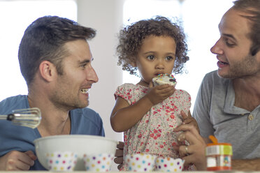 Gay couple with daughter making a cake - ZEF004280