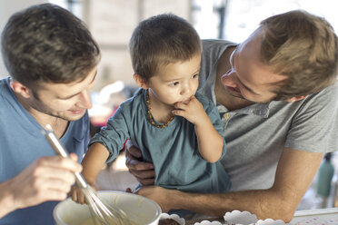 Gay couple baking cake with son - ZEF004286