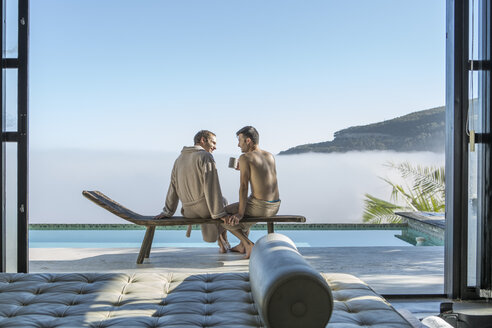 Zwei junge Männer trinken Kaffee am Pool - ZEF004303