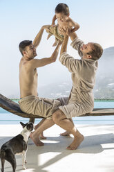 Schwules Paar spielt mit Baby am Pool - ZEF004316