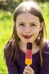 Portrait of girl with ice lolly licking lips - SARF001790