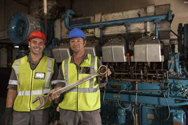 Porträt von zwei lächelnden Mechanikern im Maschinenraum eines Schiffes - ZEF005475