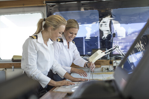 Zwei weibliche Decksoffiziere bei der Arbeit an einer nautischen Karte - ZEF005478