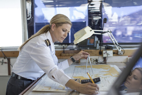 Weiblicher Decksoffizier bei der Arbeit an einer nautischen Karte - ZEF005479