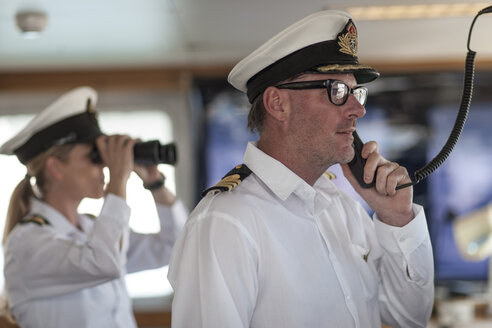 Ship captain on bridge talking on radio - ZEF005491
