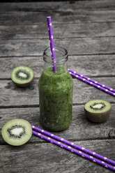 Green smoothie with kiwi, banana and mache, drinking straws, wood - SARF001749