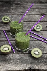 Green smoothie with kiwi, banana and mache, drinking straws, wood - SARF001751