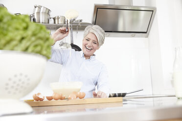 Reife Frau beim Backen in der Küche - FMKF001497