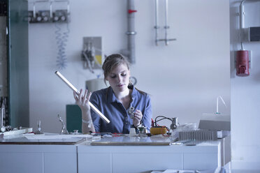 Technician in workshop holding working material - SGF001550