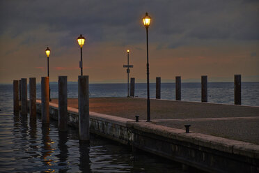 Italien, Garda, Gardasee, Seebrücke mit Laternen am Abend - MRF001623