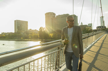 Germany, Frankfurt, businessman walking on bridge - UUF004042