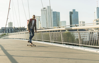 Deutschland, Frankfurt, Mann fährt Skateboard auf Brücke - UUF004044
